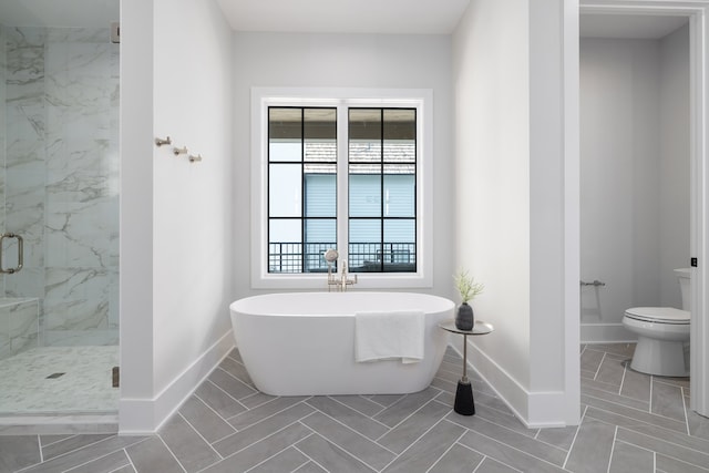 bathroom featuring plus walk in shower, tile patterned floors, and toilet