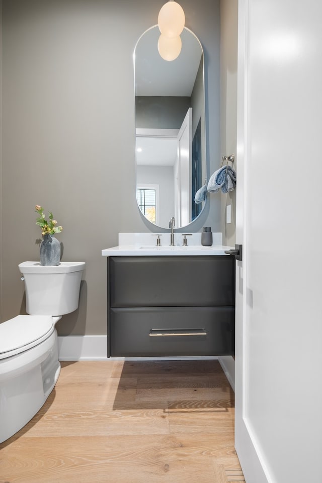 bathroom with hardwood / wood-style flooring, vanity, and toilet