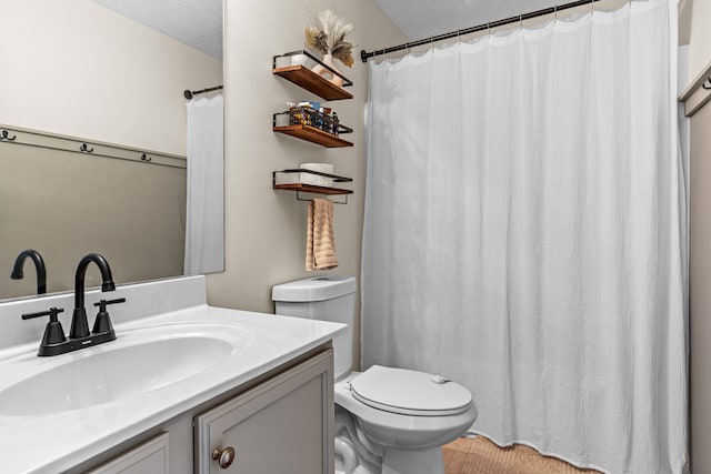 bathroom with a textured ceiling, vanity, toilet, and a shower with curtain