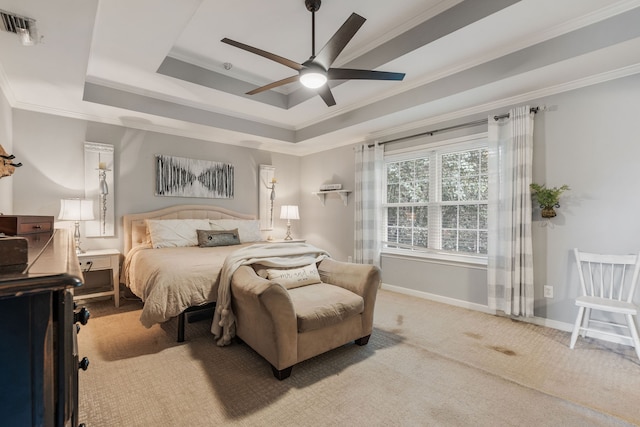 carpeted bedroom with a tray ceiling, ceiling fan, and crown molding