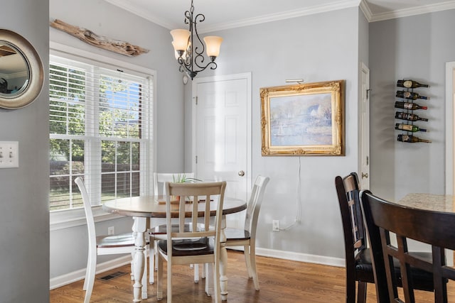 dining area featuring ornamental molding, hardwood / wood-style flooring, and an inviting chandelier