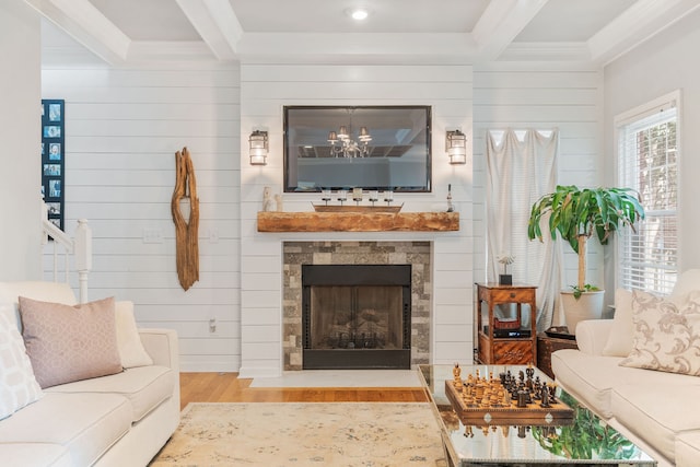 living room with light wood-type flooring, wooden walls, a fireplace, and beam ceiling