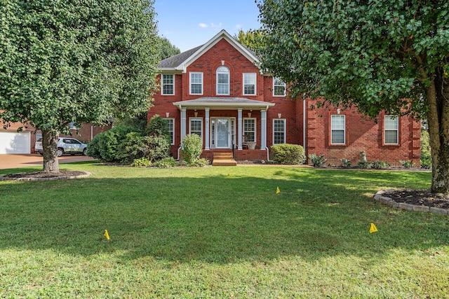 colonial inspired home featuring a front yard and a garage