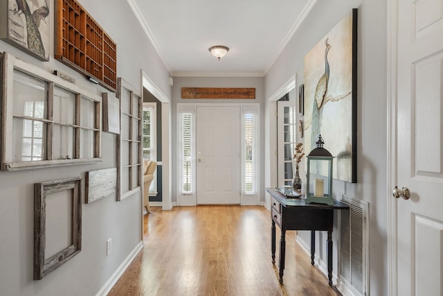 foyer entrance featuring light wood-type flooring and ornamental molding