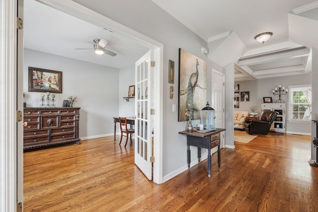 hall featuring wood-type flooring, beamed ceiling, and ornamental molding