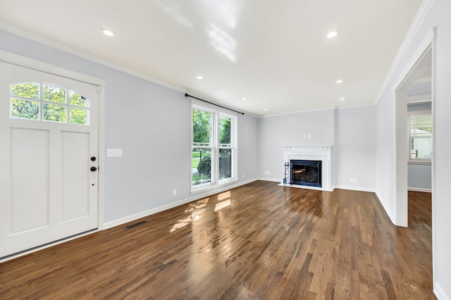 unfurnished living room featuring ornamental molding and dark wood-type flooring