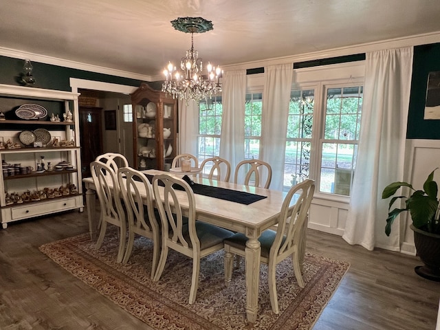 dining room featuring ornamental molding, dark wood-type flooring, and a chandelier