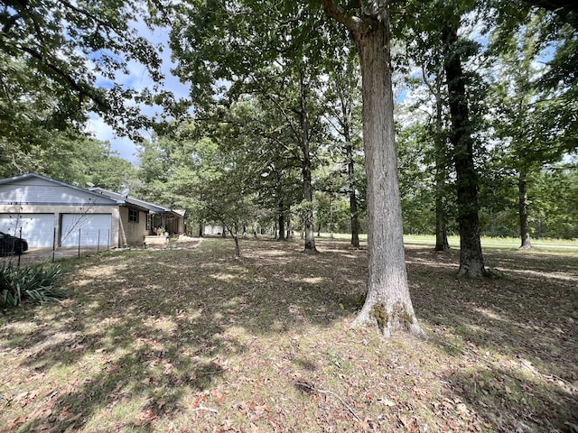 view of yard featuring a garage and an outbuilding