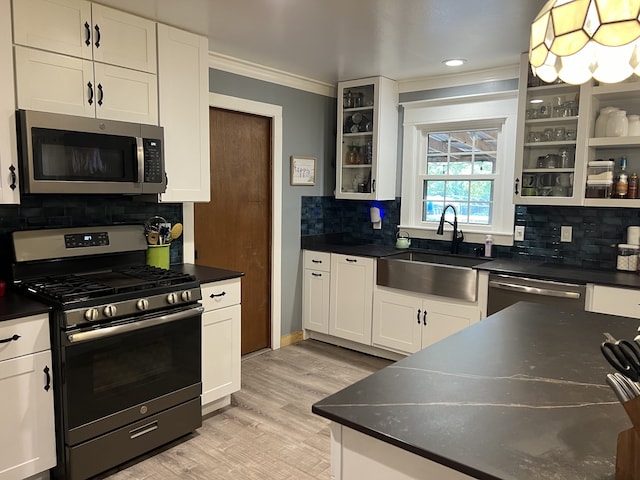 kitchen featuring white cabinets, decorative backsplash, sink, and stainless steel appliances