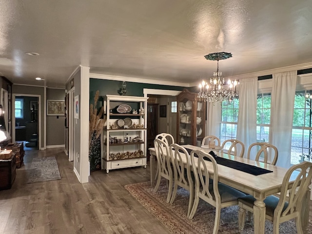 dining space with a notable chandelier, ornamental molding, and dark wood-type flooring