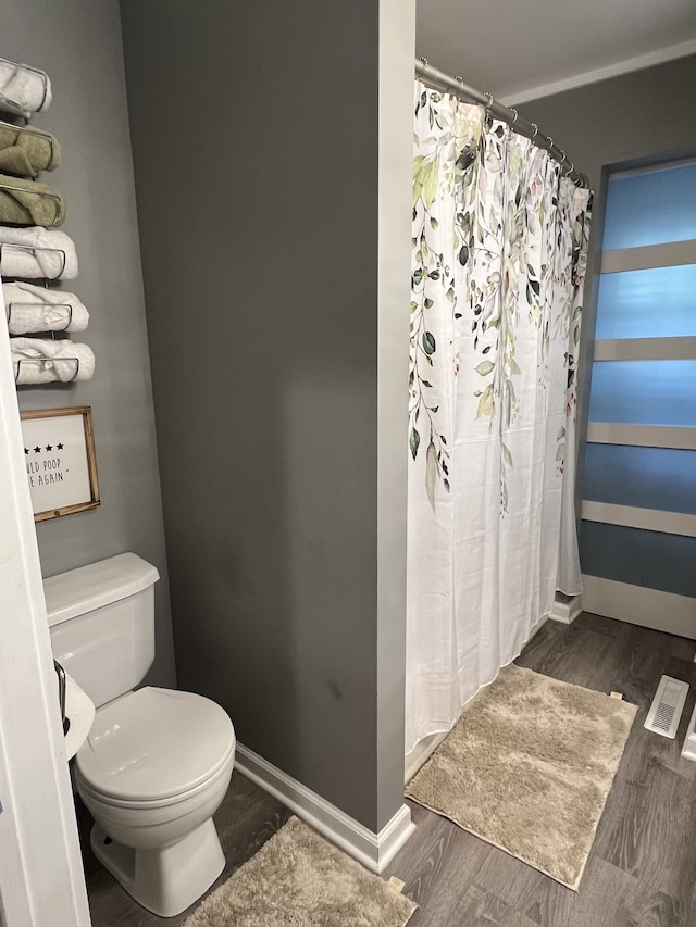 bathroom with hardwood / wood-style flooring and toilet