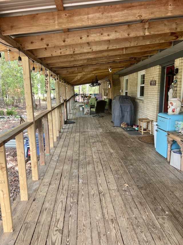 wooden deck featuring grilling area and ceiling fan