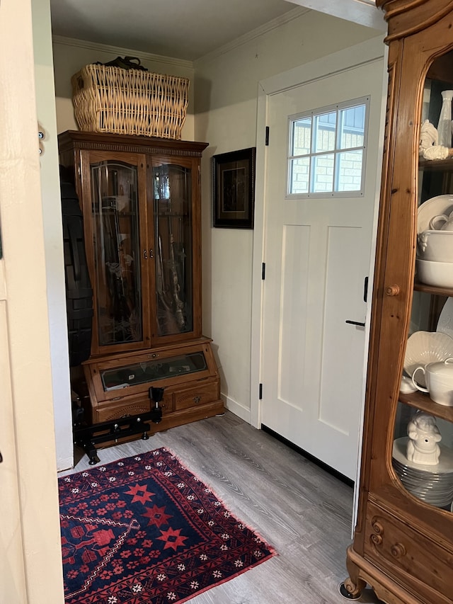 foyer entrance with hardwood / wood-style floors and crown molding