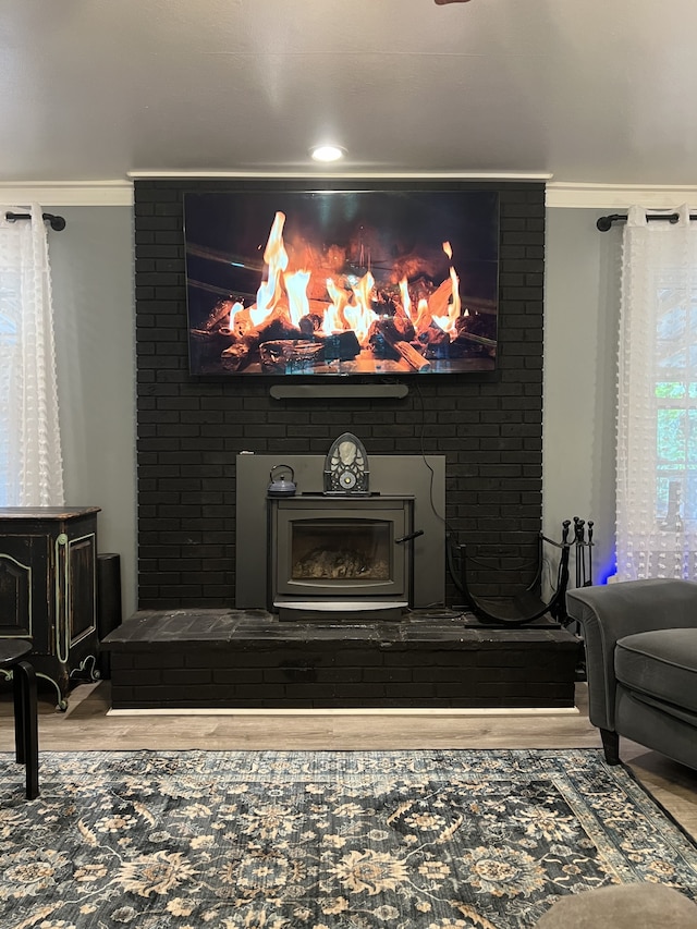 interior details with hardwood / wood-style flooring, ornamental molding, and a fireplace