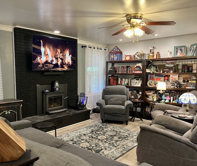 interior space with ceiling fan, light wood-type flooring, and a wood stove