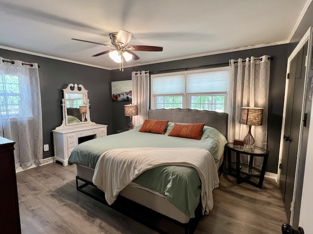 bedroom featuring wood-type flooring, ceiling fan, and crown molding