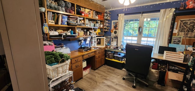 home office with light hardwood / wood-style floors and ceiling fan