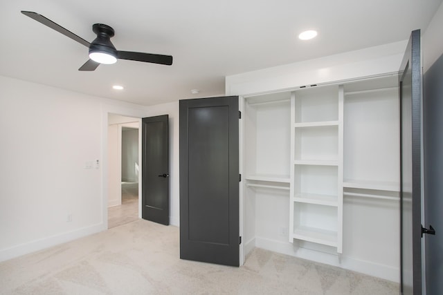 unfurnished bedroom with light carpet, ceiling fan, and a closet