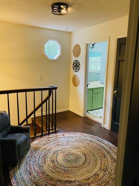 hallway featuring a textured ceiling, sink, and hardwood / wood-style floors