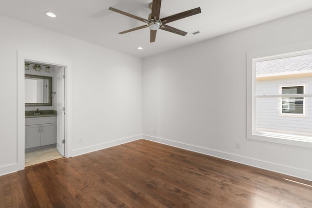 unfurnished room featuring dark hardwood / wood-style floors, ceiling fan, and sink