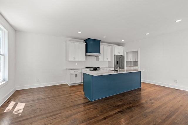 kitchen featuring white cabinetry, dark hardwood / wood-style flooring, sink, and an island with sink