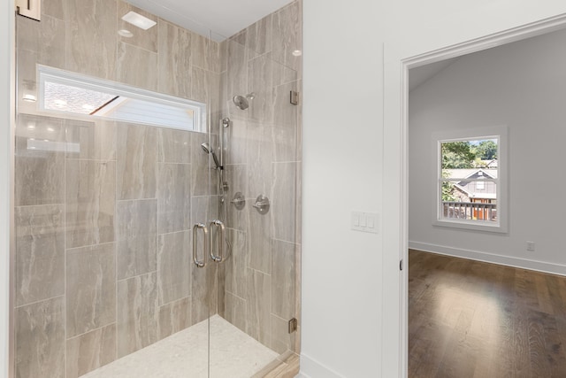 bathroom with hardwood / wood-style flooring and an enclosed shower