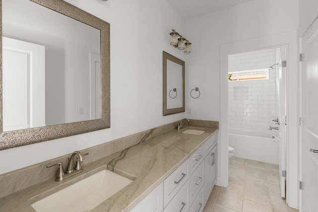 full bathroom featuring tiled shower / bath, vanity, tile patterned flooring, and toilet