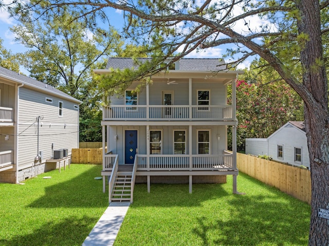 view of front of home with a balcony, central AC, a front yard, and a porch