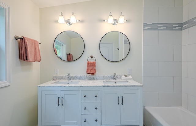 bathroom featuring vanity, vaulted ceiling, and a bathtub