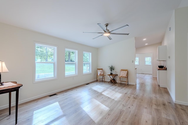 unfurnished room with lofted ceiling, ceiling fan, and light hardwood / wood-style flooring