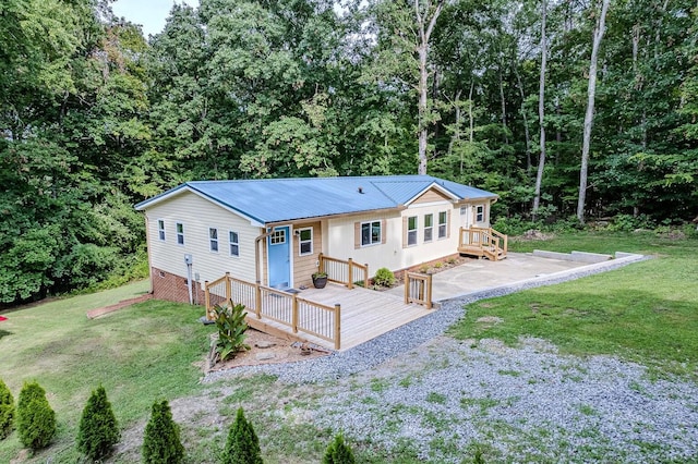 rear view of property featuring a wooden deck and a yard