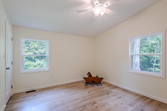 unfurnished room with light hardwood / wood-style flooring, lofted ceiling, ceiling fan, and a healthy amount of sunlight