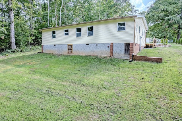 rear view of property with a lawn and a wooden deck