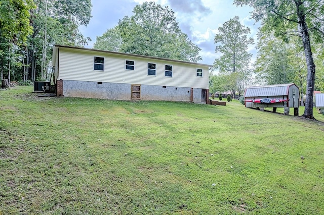 back of property with a lawn and central air condition unit