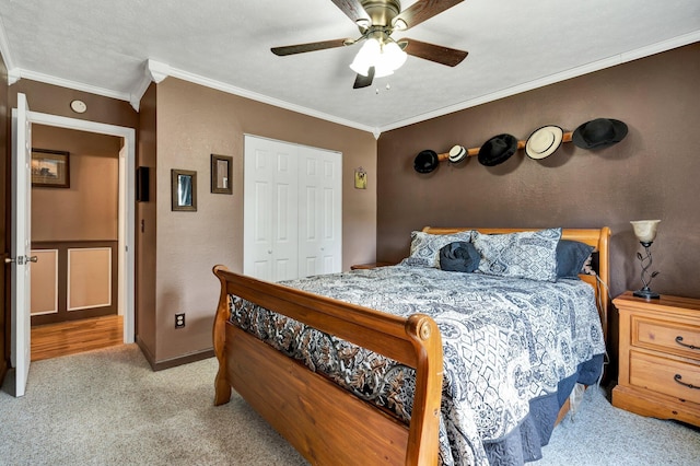 carpeted bedroom with ceiling fan, a textured ceiling, a closet, and crown molding