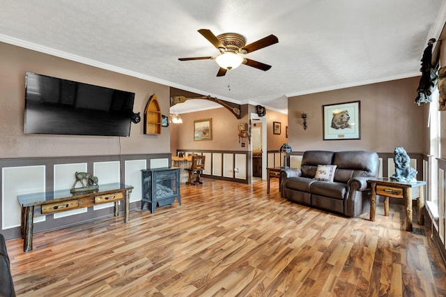 living room featuring a textured ceiling, ornamental molding, ceiling fan, and hardwood / wood-style flooring