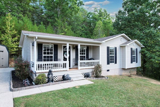 view of front of home with a storage shed, covered porch, and a front lawn