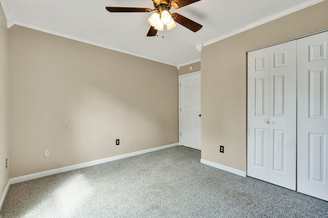 unfurnished bedroom featuring a closet, carpet, ceiling fan, and crown molding