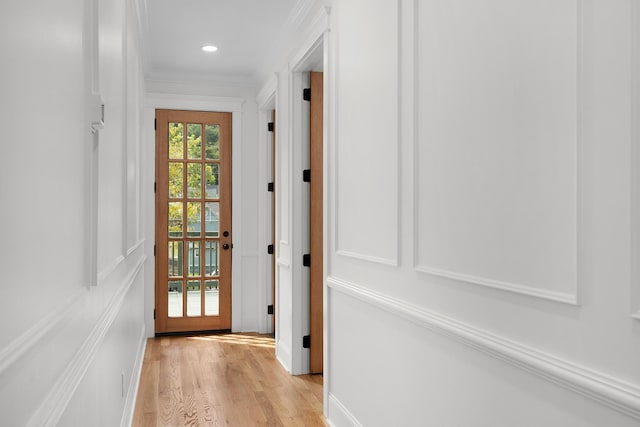 doorway to outside with light hardwood / wood-style floors and ornamental molding