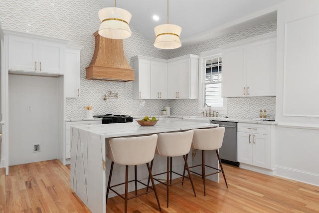 kitchen with dishwasher, white cabinetry, and a center island