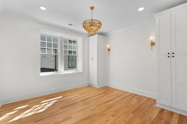 unfurnished room featuring ornamental molding, light hardwood / wood-style floors, and a chandelier