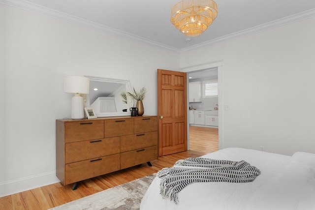 bedroom featuring ornamental molding, light hardwood / wood-style flooring, and a notable chandelier