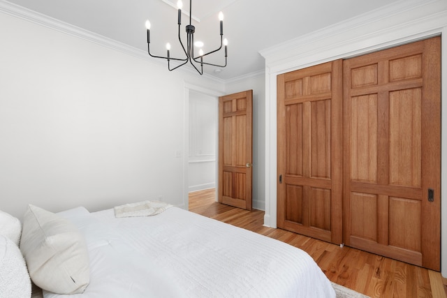 bedroom featuring light hardwood / wood-style floors, a closet, and crown molding