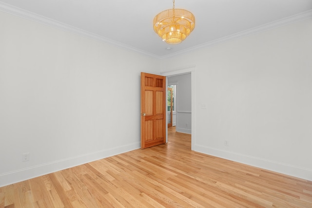 spare room featuring an inviting chandelier, crown molding, and light hardwood / wood-style flooring