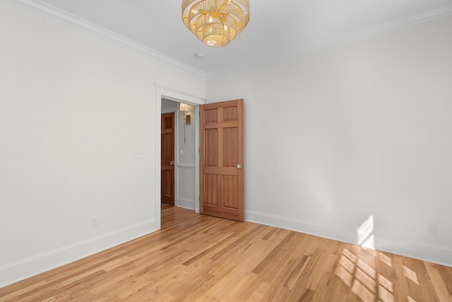 unfurnished room with light hardwood / wood-style floors, crown molding, and an inviting chandelier