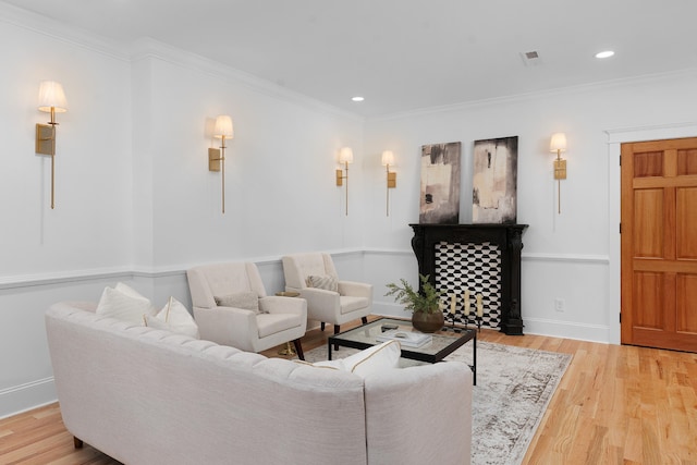 living room featuring ornamental molding and light hardwood / wood-style floors