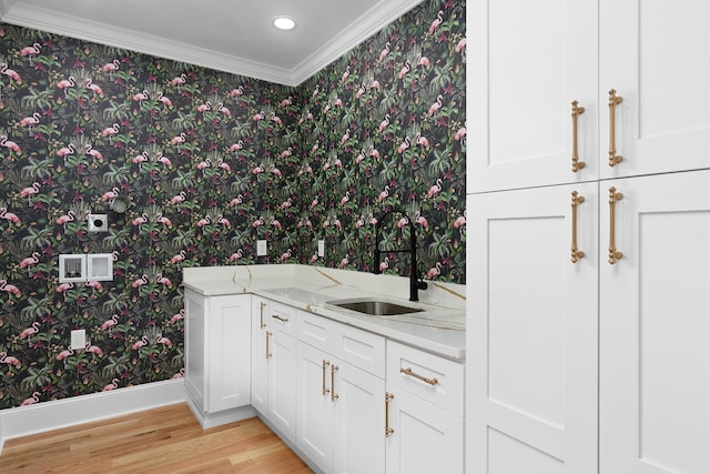 bathroom featuring ornamental molding, hardwood / wood-style floors, and sink