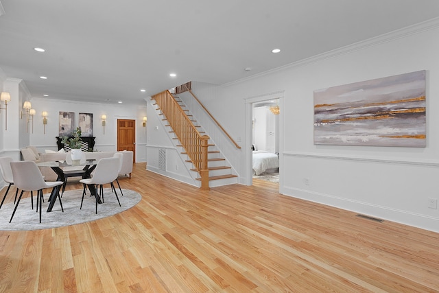 dining space featuring crown molding and light hardwood / wood-style flooring