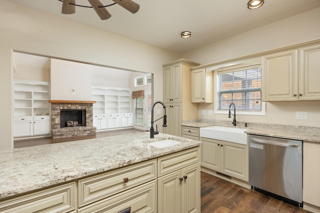 kitchen featuring sink, dishwasher, dark wood-type flooring, and cream cabinets