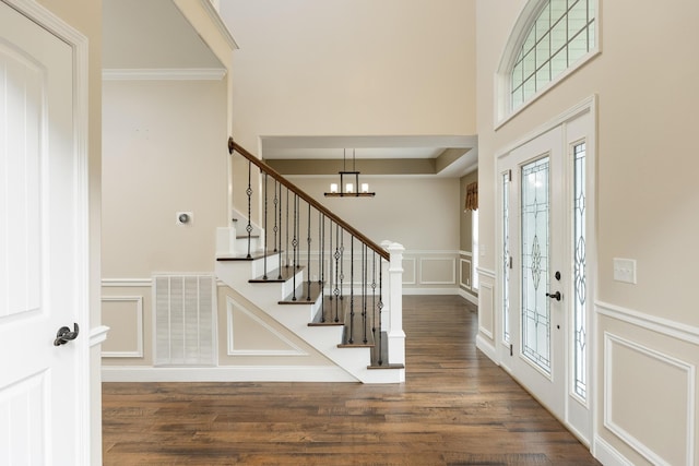 entrance foyer with crown molding, dark hardwood / wood-style floors, and a chandelier